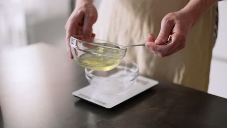 Man-Poring-Egg-White-And-Measure-It-On-Kitchen-Scale