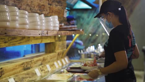 flambe - chef tossing wok over high flame in kitchen of restaurant