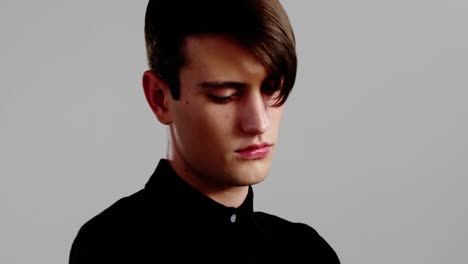 androgynous man posing against grey background