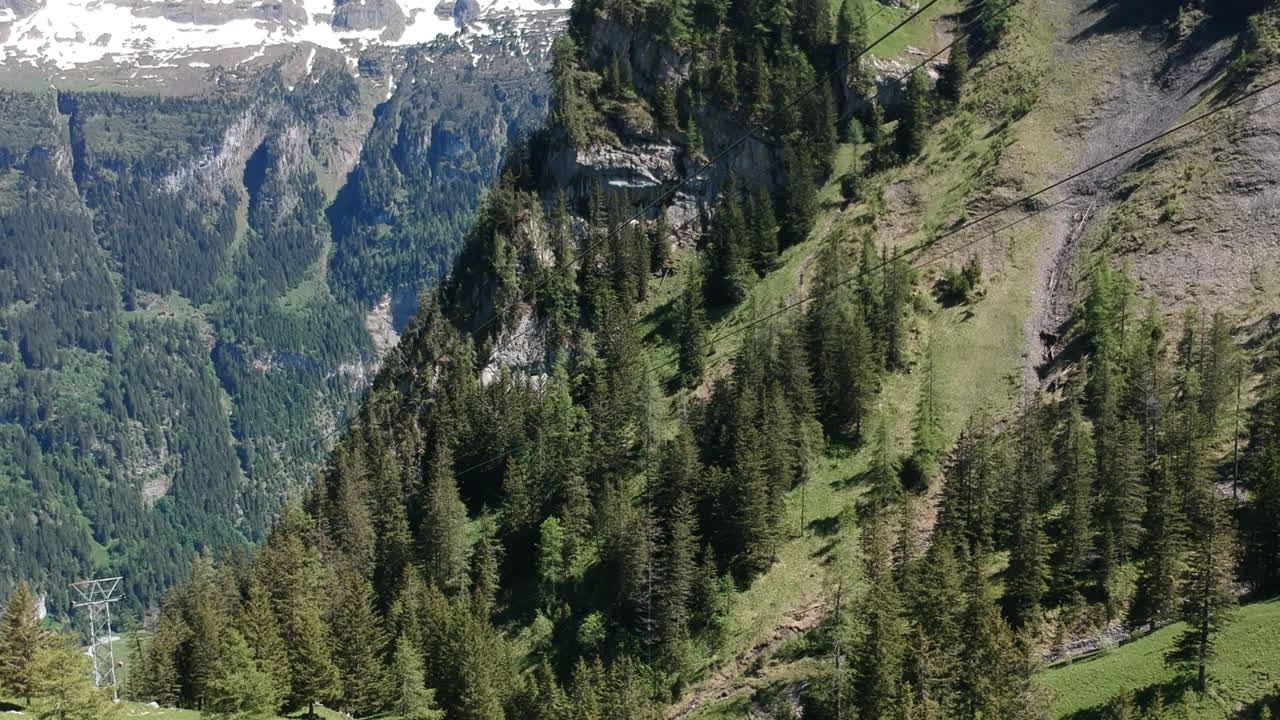 канатная дорога медленно спускается через швейцарские альпы среди бесконечных гор