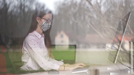 mujer de negocios en una oficina en casa durante una pandemia con una máscara protectora