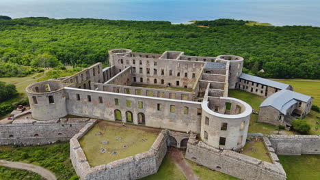 Famosa-Fortaleza-Del-Castillo-De-Borgholm-Con-El-Bosque-Verde-Y-El-Estrecho-De-Kalmar-En-El-Fondo-Durante-El-Día-En-Öland,-Borgholm,-Suecia