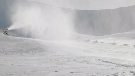 Snowboarder-amidst-the-mist-of-freshly-made-snow-on-flat-ski-slope