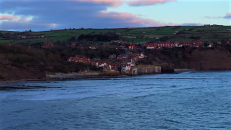 low wide angle establishing drone shot of robin hood's bay yorkshire