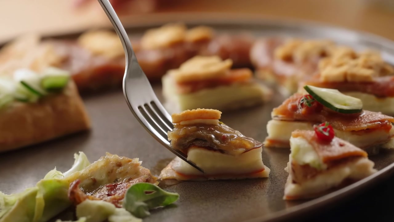 Arrangement og presentasjon av minipizzaer i et kjøkken eller spiseområde. Inkluderer minipizzaer, en treoverflate, metallgaffel og plasttallerken-tekstur.