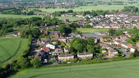 Establishing-tilt-up-aerial-shot-of-the-landscape-in-Cronton-village-with-view-of-the-fields-and-beautiful-idyllic-dwellings