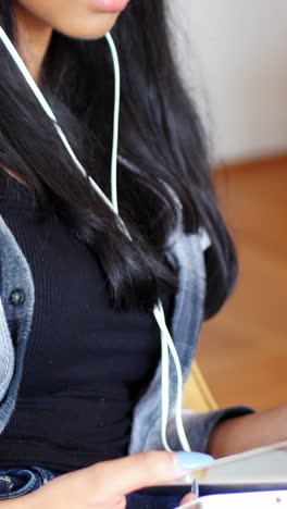 mujer escuchando música con auriculares de su tableta digital