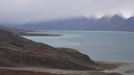 Fiordo-Segelsallskapet,-Costa-De-Groenlandia,-Colinas-De-Piedra-Caliza-Y-Picos-Nevados-En-Temporada-De-Verano