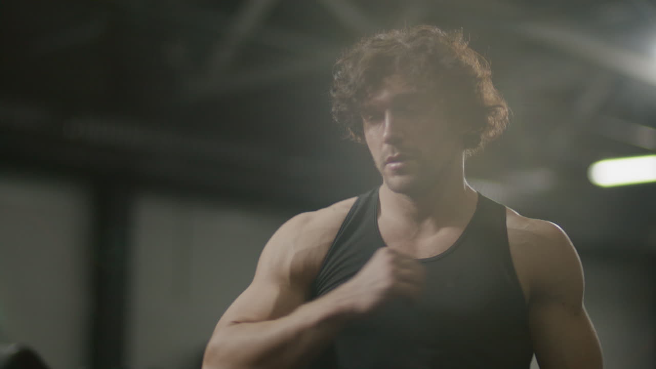 Strong Man Performing Seated One-Arm Rows on Rowing Machine at Gym