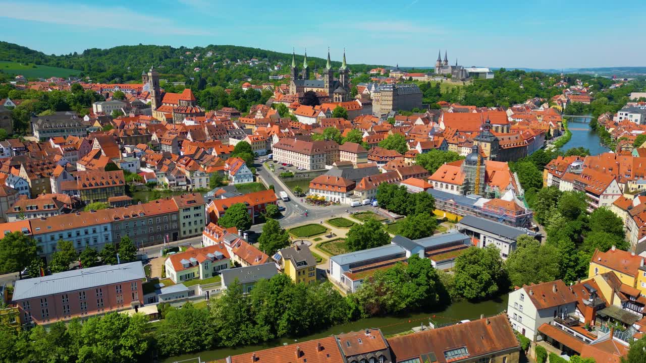 Video aereo 4K con drone della splendida Cattedrale di Bamberga e delle Chiese dell'Abbazia di Michaelsberg lungo il fiume Regnitz nella zona della Città Vecchia del centro di Bamberga, Germania.