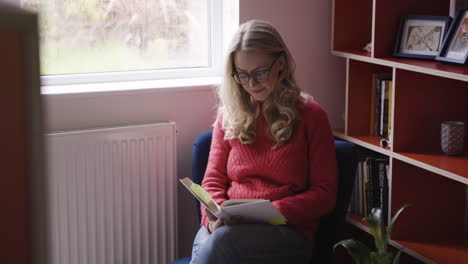mujer leyendo un libro en una habitación acogedora