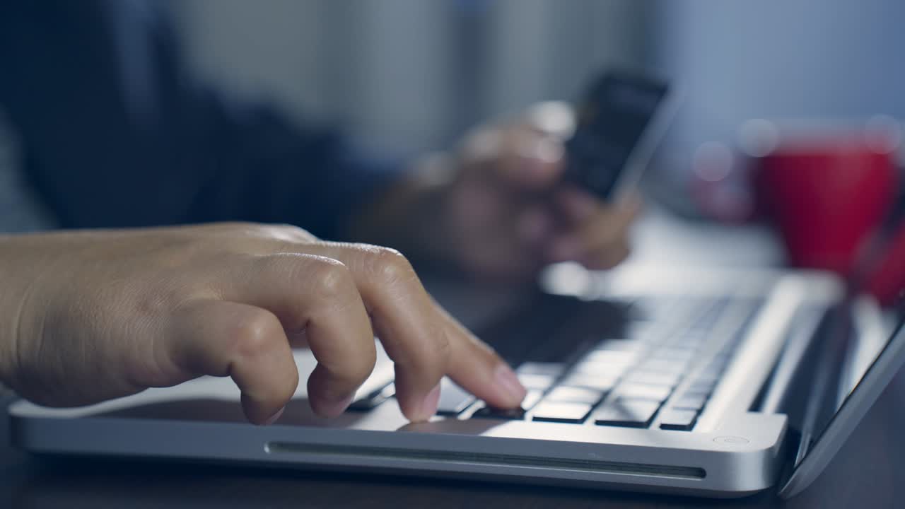 b rodar el movimiento lento de la mano escribiendo el teclado y haciendo compras en línea mientras sostiene la tarjeta de crédito. el titular de la tarjeta sostiene la carta de crédito haciendo pago en línea de e-bank. pagar por la compra en la tienda web usando una computadora portátil