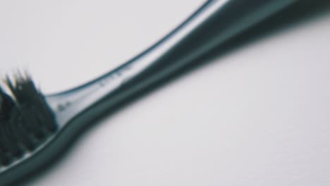 unusual toothbrush with black bristles on white background