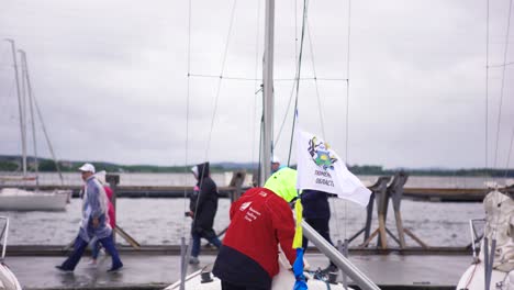 sailors preparing for a race on a cloudy day