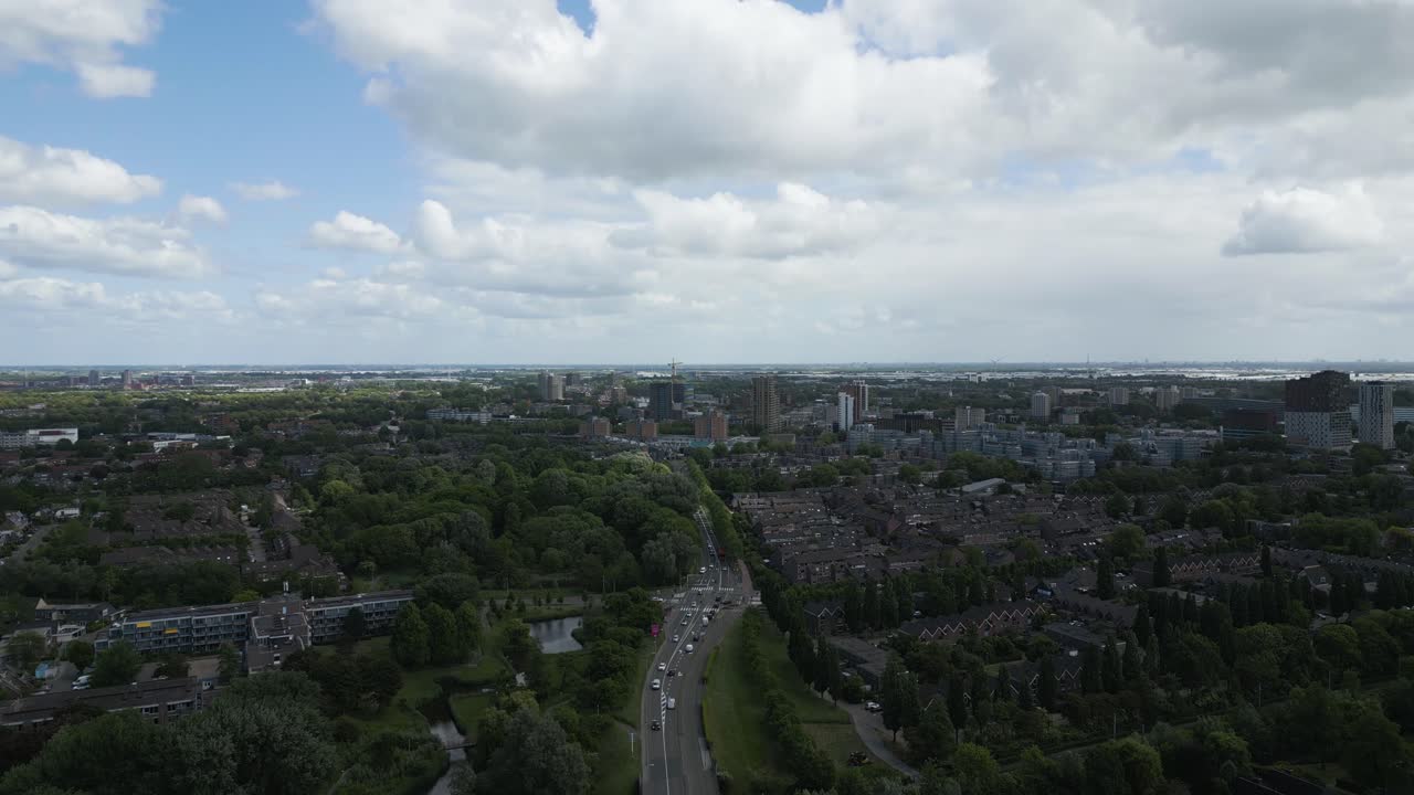 A high-altitude drone view over a densely populated city in the Netherlands, revealing urban sprawl and natural surroundings.