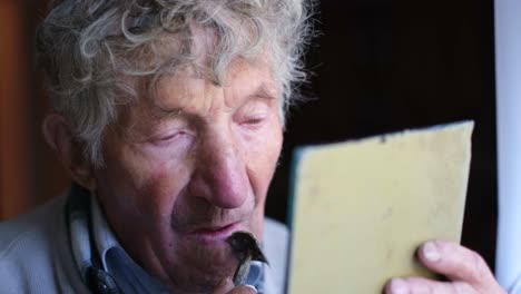 elderly man shaving looking in mirror