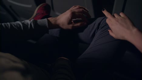 Love-couple-flirting-at-cinema.-Man-and-woman-holding-hands-at-cinema-chairs