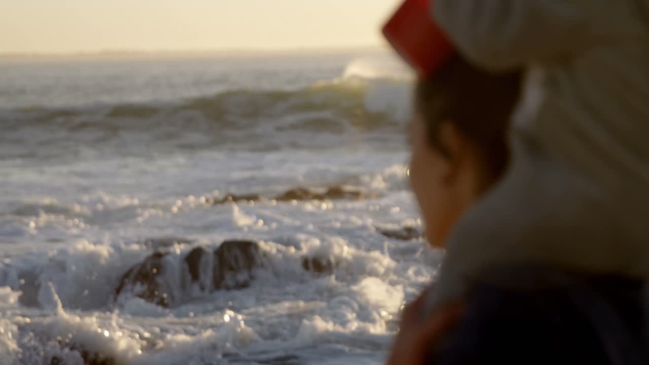 엄마가 해변에서 아기 소년과 함께 놀고 있습니다.