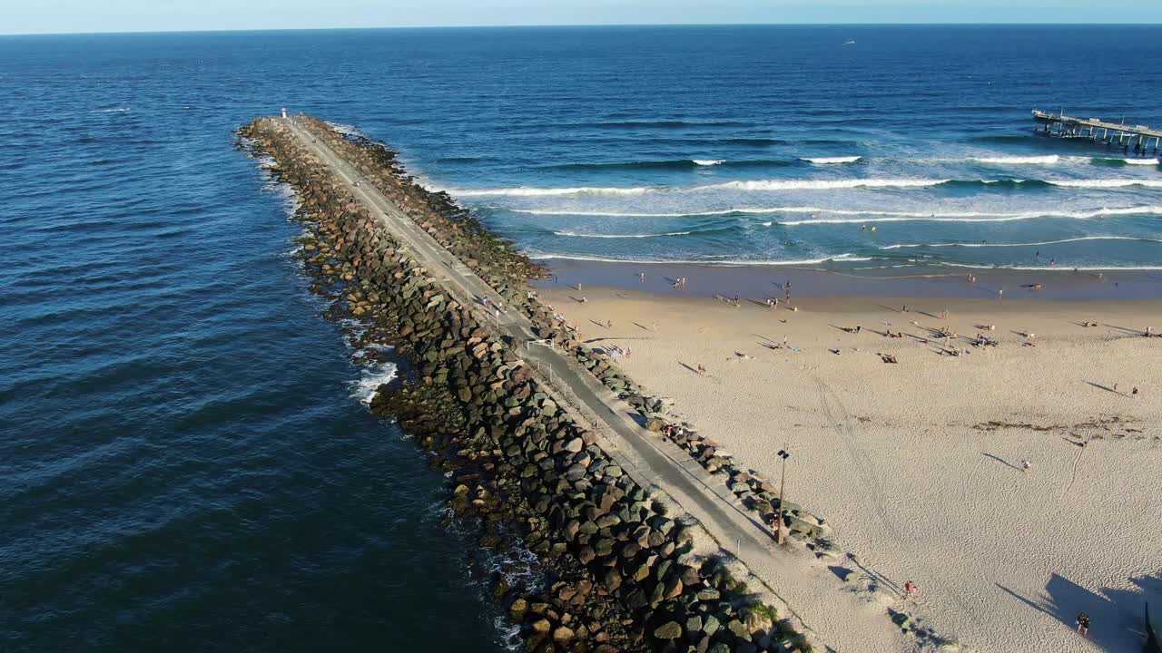Hovering, looking out over rock seawall and sand pumping jetty sunset, Gold Coast