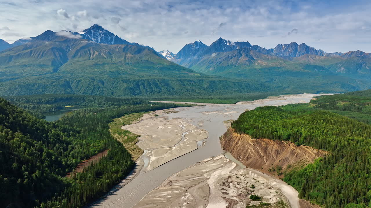 Wide river delta in Alaska. Sprawling Alaskan river delta flowing toward rugged green mountain slopes
