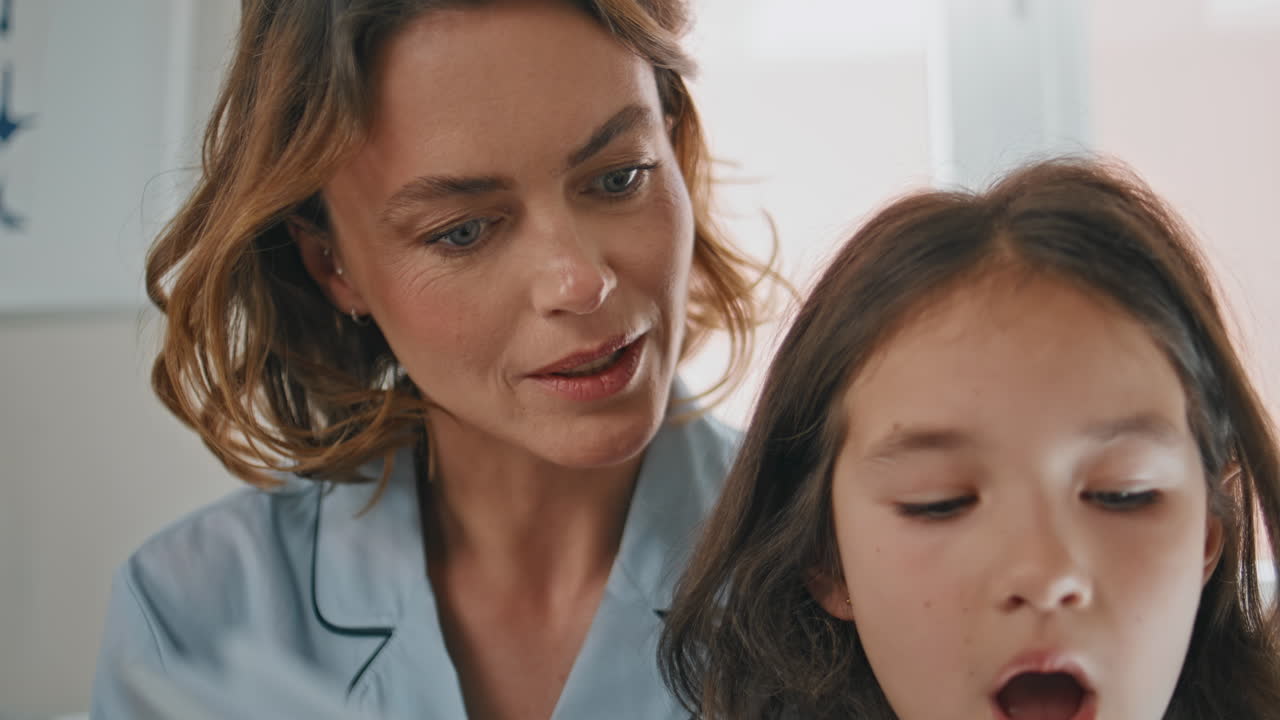 Toddler girl reading book for mother resting together at weekend morning closeup