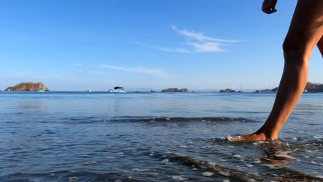 Mujer-Caminando-En-La-Playa-Al-Amanecer-Durante-Las-Vacaciones-De-Verano,-Cierre-De-Piernas-Y-Pies-En-El-Agua-Del-Mar