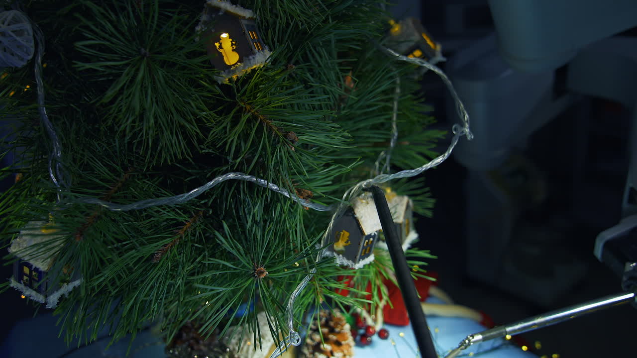 Futuristic surgical equipment decorating Christmas tree. High technological equipment hanging Christmas garland on the fir-tree. Close up.