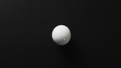 Close-up-of-golf-ball-on-black-background,-copy-space,-slow-motion