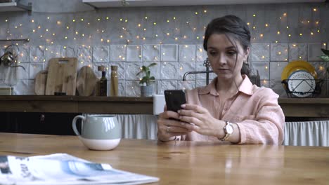 mujer usando el teléfono en la cocina
