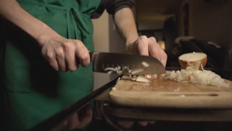 cebollas blancas cortadas en una tabla de cortar de madera por manos de un chef