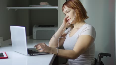 mujer feliz escuchando música y escribiendo en una computadora portátil