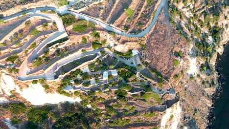 toma aérea de la costa con una carretera en zigzag que conduce a la montaña