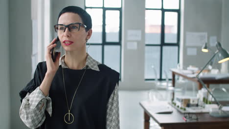 hermosa mujer de negocios de mediana edad hablando por teléfono en la oficina