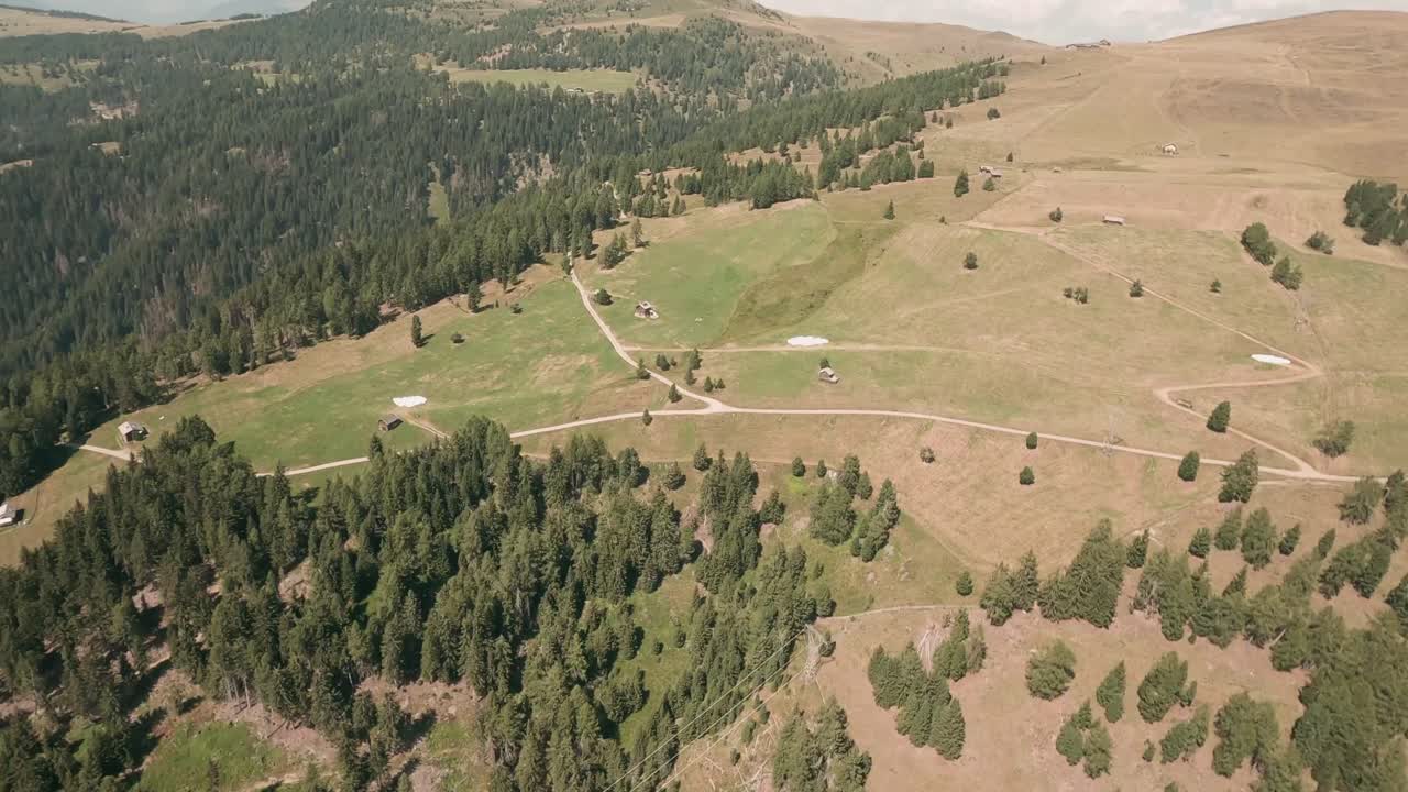 Thrilling FPV drone footage captures close flybys between trees and wooden huts above Luzen village's hills
