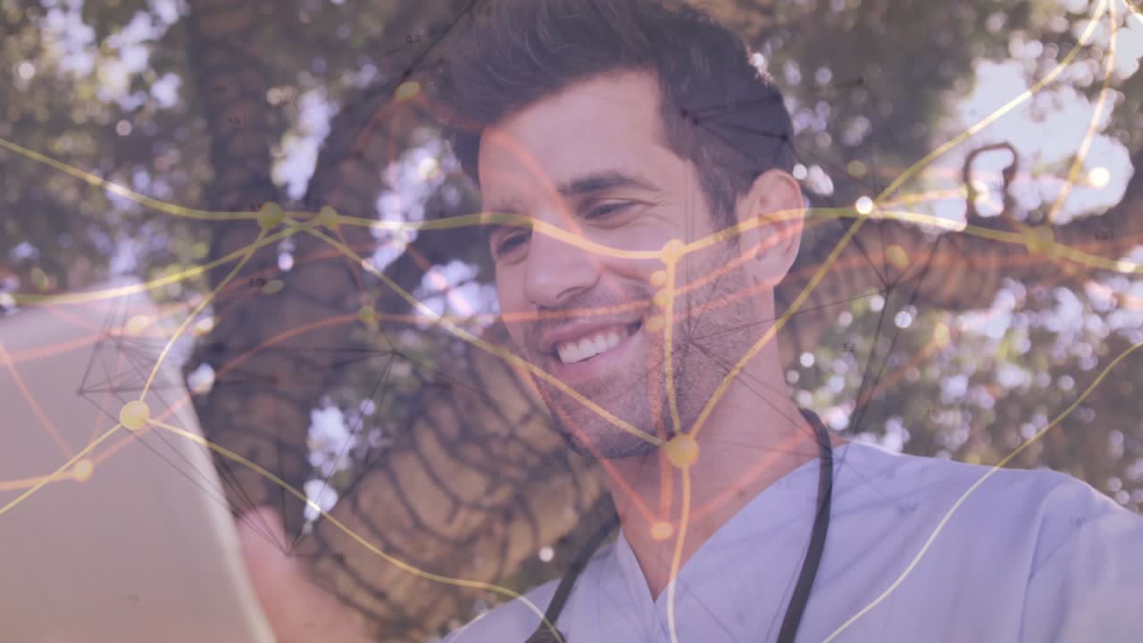 Male doctor tapping tablet under tree reviewing patient data as network graphic growing over frame