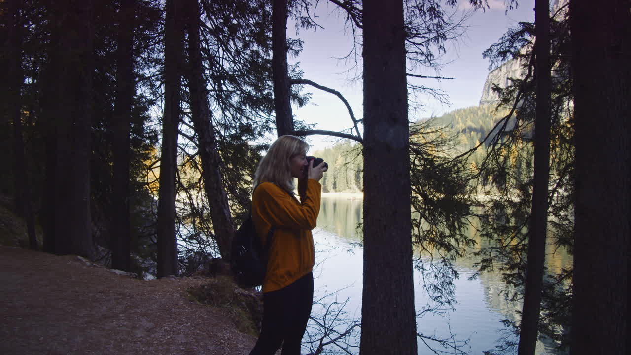 Mulher loira fotografa no Lago Braies, na Itália
