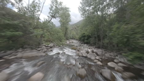 fpv drone vuela a lo largo del arroyo del río cerca de la corriente de agua en esterri d'aneu