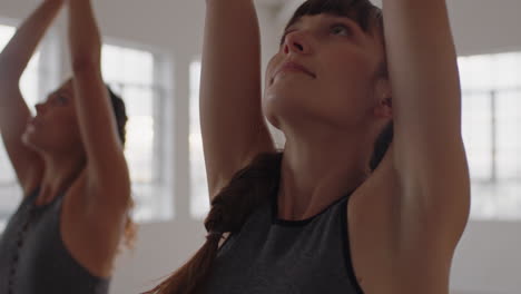 Clase-De-Yoga-Hermosa-Mujer-Caucásica-Practicando-Pose-Guerrera-Con-Un-Grupo-Multirracial-De-Mujeres-Disfrutando-De-Un-Estilo-De-Vida-Saludable-Haciendo-Ejercicio-En-El-Gimnasio-Al-Amanecer