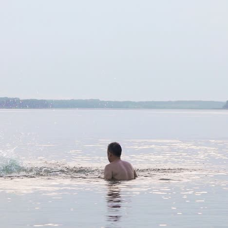 happy family. father and son are having fun and splashing in the water. slow motion.