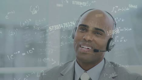 Animation-of-numbers-over-businessman-with-headset-in-office