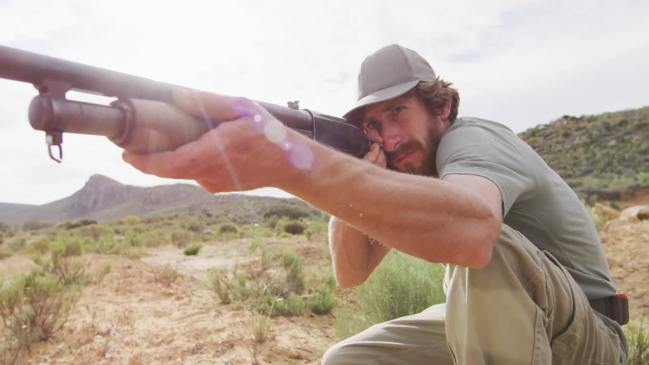 무 ⁇ 을  ⁇ 고 있는 백인 남성 생존가 들 이 야생 에서 사냥 소총 을 겨냥 하고 있다