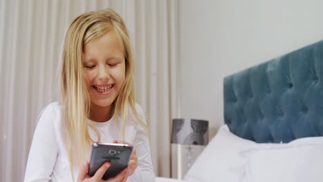 Happy-girl-using-mobile-phone-on-bed-4k