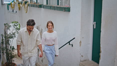 enamoured pair stepping staircase at south city. romantic couple holding hands