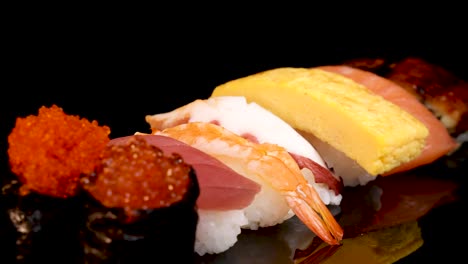 a vibrant assortment of nigiri, sashimi, and gunkan sushi rotates smoothly on a glossy black surface under bright, even lighting, highlighting fresh seafood and colorful presentation