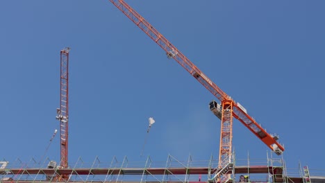 low angle of yellow crane in motion against blue sky.
