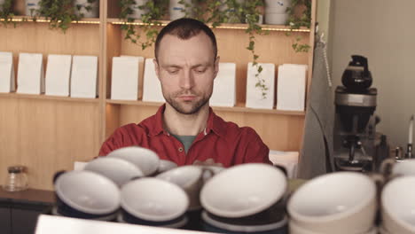 male caucasian barista making coffee in cafe