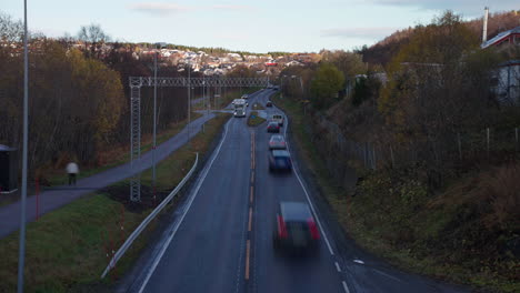 Timelapse-Del-Tráfico-Por-Carretera-Con-Vehículos-A-Alta-Velocidad-Durante-La-Puesta-De-Sol-En-Otoño-En-Tromso,-Noruega