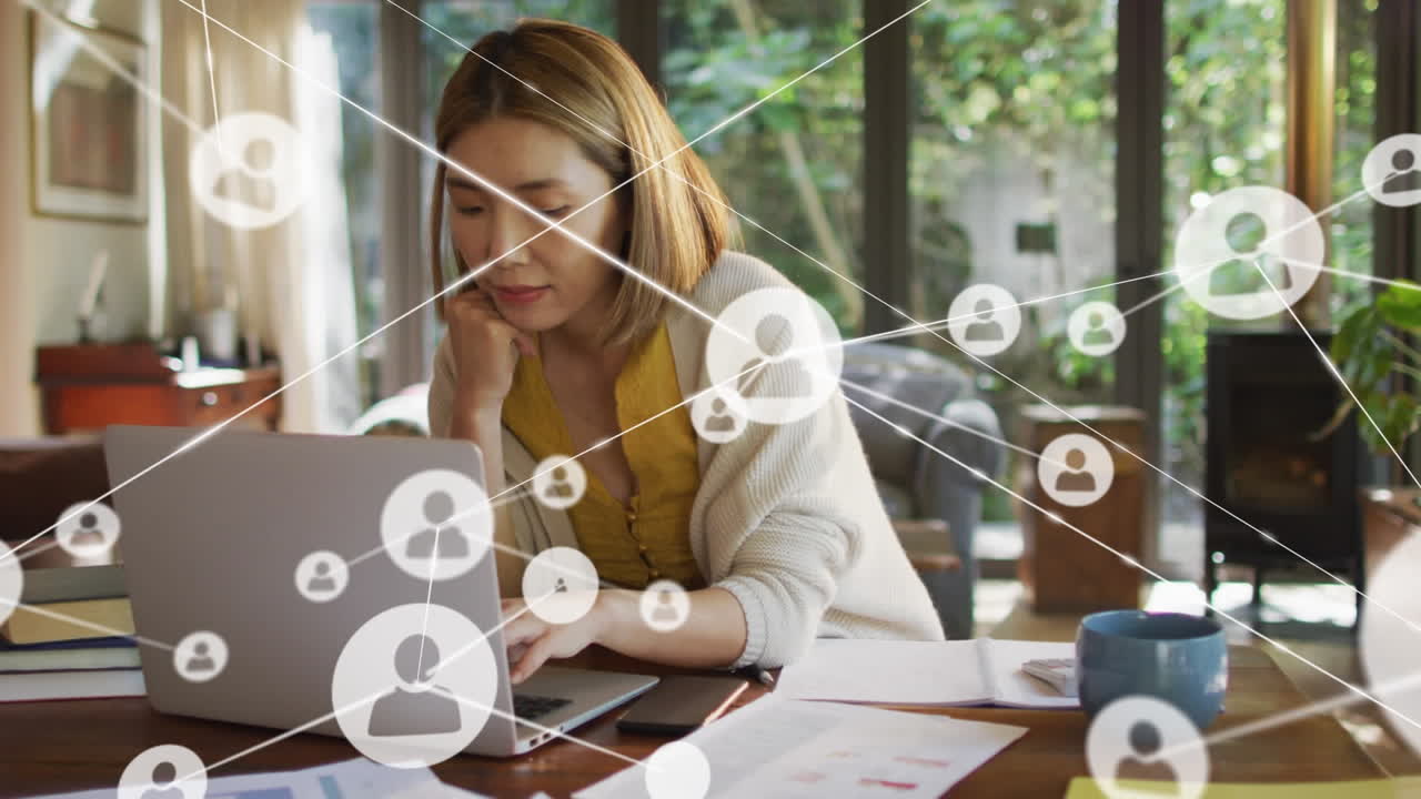animación de iconos de los medios sobre una mujer asiática sonriente usando una computadora portátil