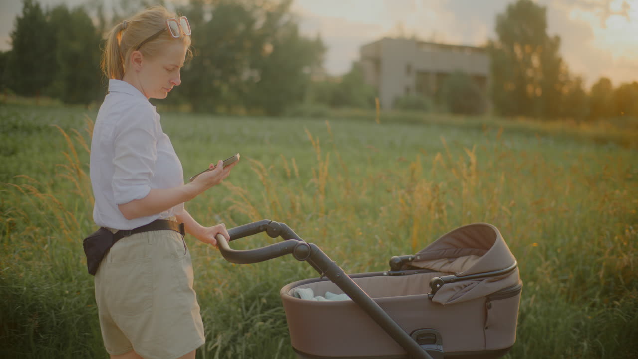 Woman Walking with Child and Stroller at Sunset