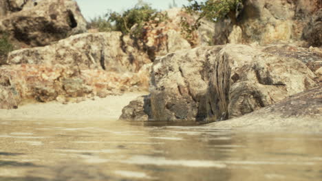 oasis desértico sereno: agua quieta que refleja las rocas y la arena